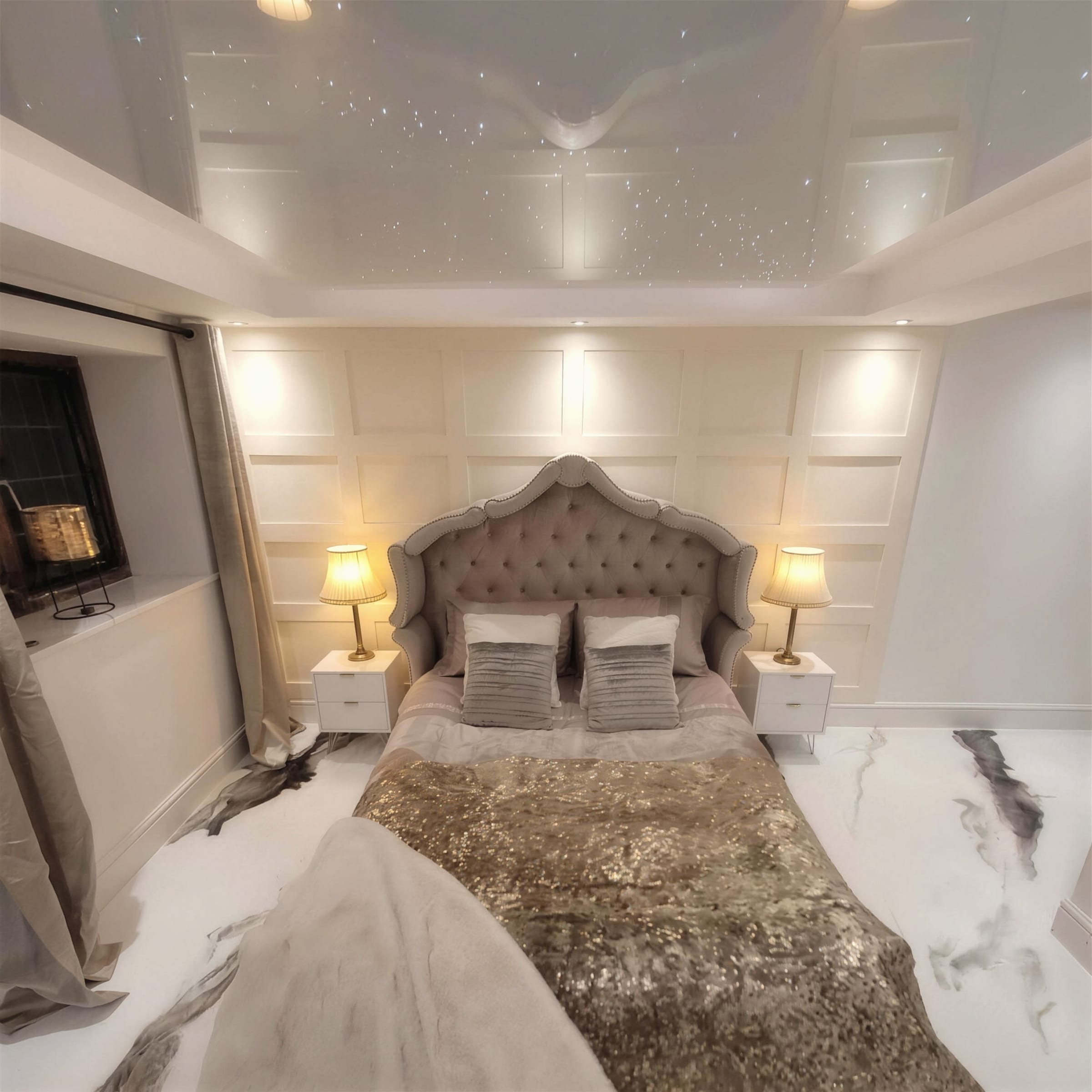 Panelled cream bedroom with an upholstered bed, glossy metallic marble floor and faint fibre-optic pinpoints across a gloss stretch ceiling.